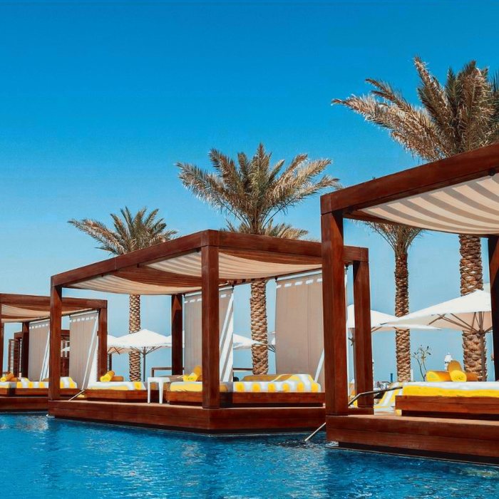 The two nearest cabanas at Emerald Pool, striped canvas overhead and the water below the decks