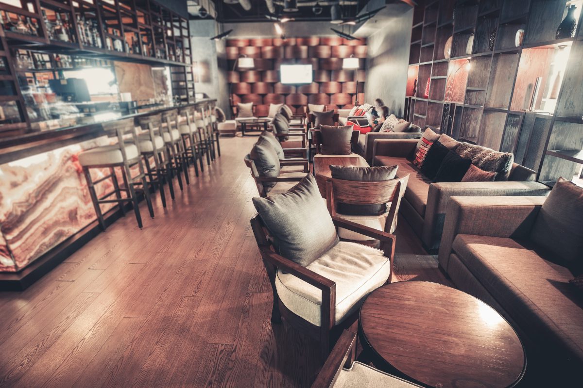 The lounge from the door, the lit bar on the left and seating groups down the right
